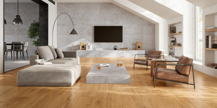 C. Bergmann zeigt ein Wohnzimmer mit Dielenfliesen in Holzoptik von Monocibec, grauer Couch und tiefen braunen Stühlen.