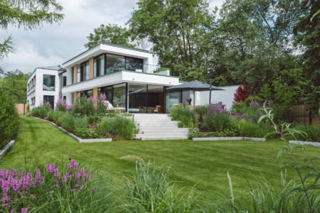 Villa mit Balkon, Terrassenaufgang, Garten und Ganzglassystem und Hebeschiebetüren von Josko.