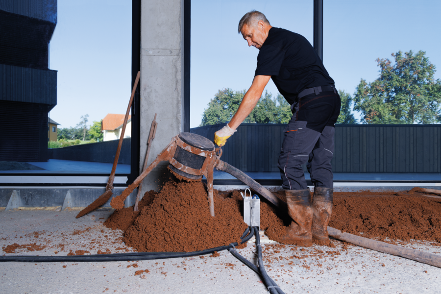 Arbeiter beim Fußbodenaufbau mit thermotec® in einem Raum mit bodentiefen Fenstern von thermotec®.