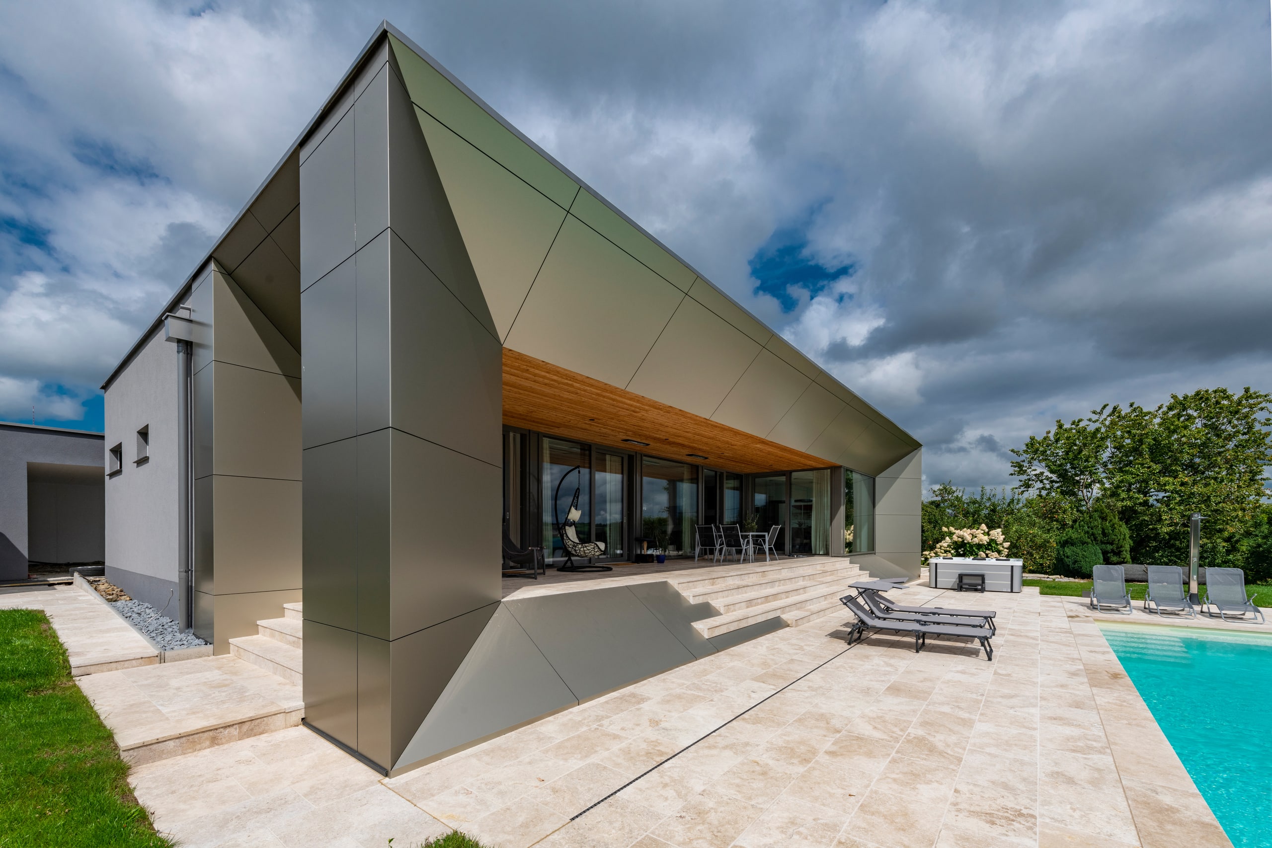 Moderne Flachdach-Villa mit grosser integrierter Terrasse und breitem Stiegenabgang zum Pool von AL Architekt.