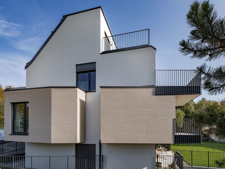 Austrotherm zeigt gedämmtes Wohnhaus mit moderner Wellenfassade.