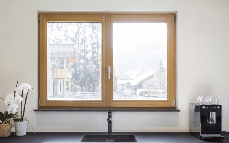 Moderner Küchenbereich mit einem Holz-Alu-Fenster von Gaulhofer.