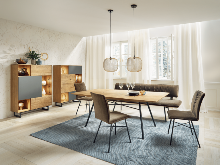 WOHNHAUS Grill & Ronacher zeigt eine moderne Essgruppe von ANREI, bestehend aus einem Esstisch aus dem Holz der Astnuss sowie Sideboards aus dem Holz der Asteiche barrique Steingrau sowie Stühle mit Stoffbezug sowie Sideboards und Highboards.