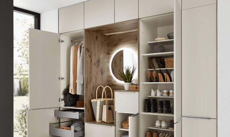 Einbaugarderobe mit beigen Fronten und Ablagebereich in Holzoptik von Nobilia präsentiert von Grill & Ronacher.