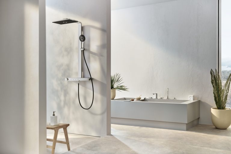 Badezimmer mit barrierefreier Duschnische mit Regendusche Handbrause und einer Armatur mit Temperaturregelung in Chrome und einer rechteckigen Badewanne mit Brausestaub von GROHE.