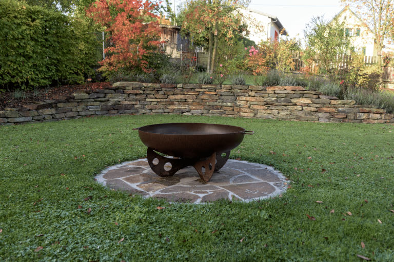 Herbstlicher Garten mit Feuerschale und Steinmauer, angelegt von Gartengestalter Hablesreiter.