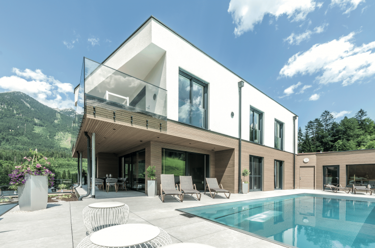 Großflächige Terrasse mit Pool, Glasgeländer-Balkon, großflächigen Bodenfliesen und großen Fensterflächen und Glasschiebetür von Internorm.