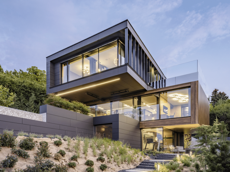 Moderne hanggebaute Villa mit Holzdielen, Terrasse, Flachdach und bodentiefer Verglasung von Internorm.