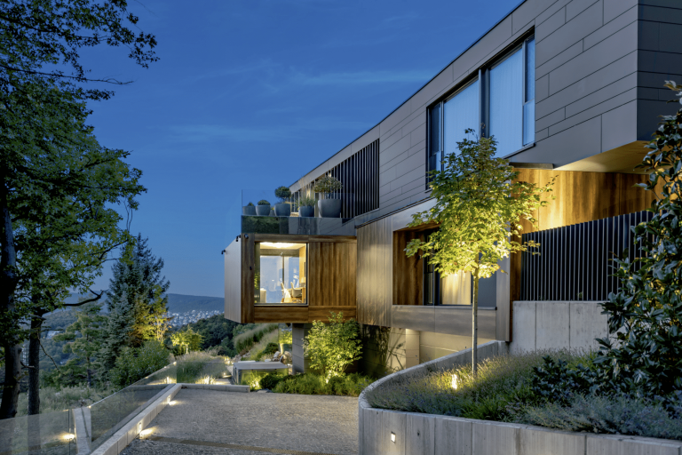 Internorm zeigt eine moderne Villa mit großer Einfahrt in die Garage, Dachterrasse, Glaswänden und Hebeschiebetüren.png