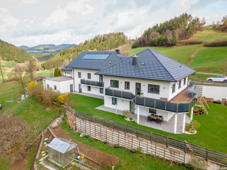 Doppelhaus mit Zeltdach, großen Balkonflächen mit Glasgeländer, Terrasse und großem Garten von B. Kern Baugesellschaft.