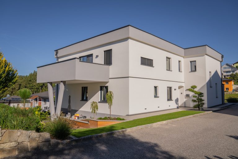 Einfamilienhaus mit Flachdach und großzügigem Balkon der als Terrassenüberdachung dient von B. Kern Baugesellschaft.