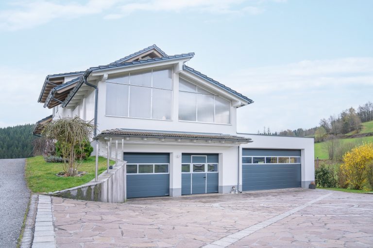 Einfamilienhaus mit Pult- und Satteldach, großer Glasfront mit Giebelfenster und Doppelgarage von B. Kern Baugesellschaft.