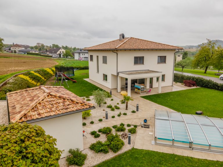 Einfamilienhaus mit Zeltdach aus Tonziegeln, überdachter Terrasse und Gartenhütte von B. Kern Baugesellschaft.