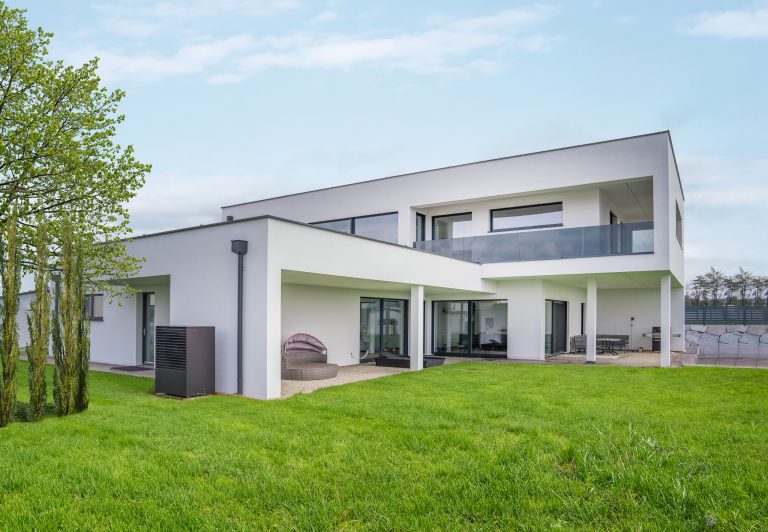 Modernes kubisches Haus mit dunkel verglastem Balkongeländer und bodentiefen Fenstern von B. Kern Baugesellschaft.