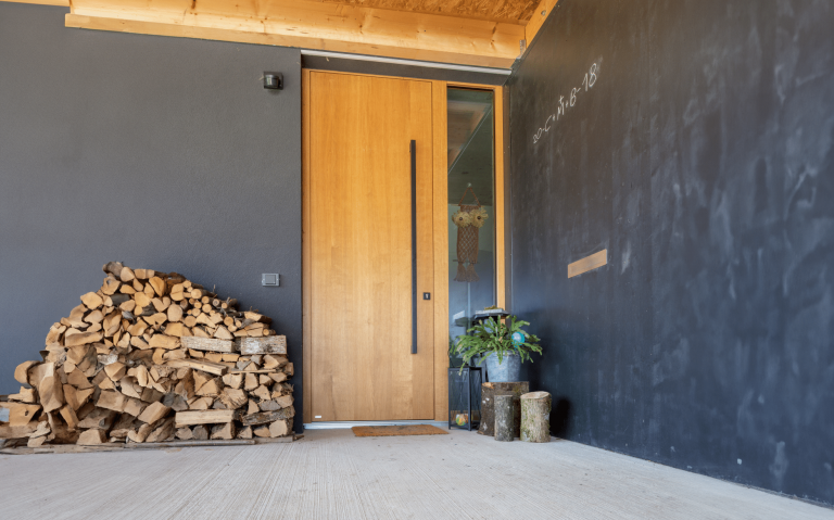 Moderne Hauseingangstür aus Holz mit einem seitlichen, raumhohen Glaselement der Firma Maderböck.