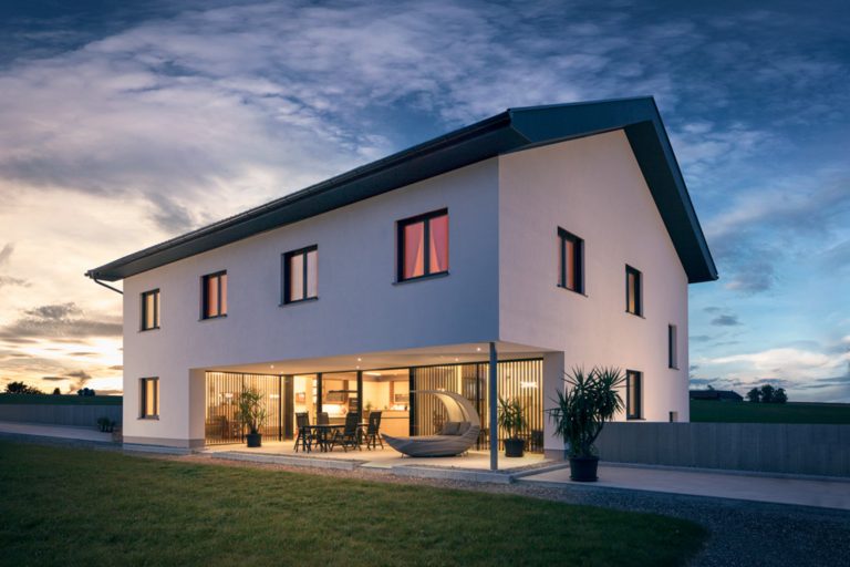 Klassisches Einfamilienhaus mit nach innen versetzter Terrasse und großen barrierefreien Glasschiebtüren von Maderböck.