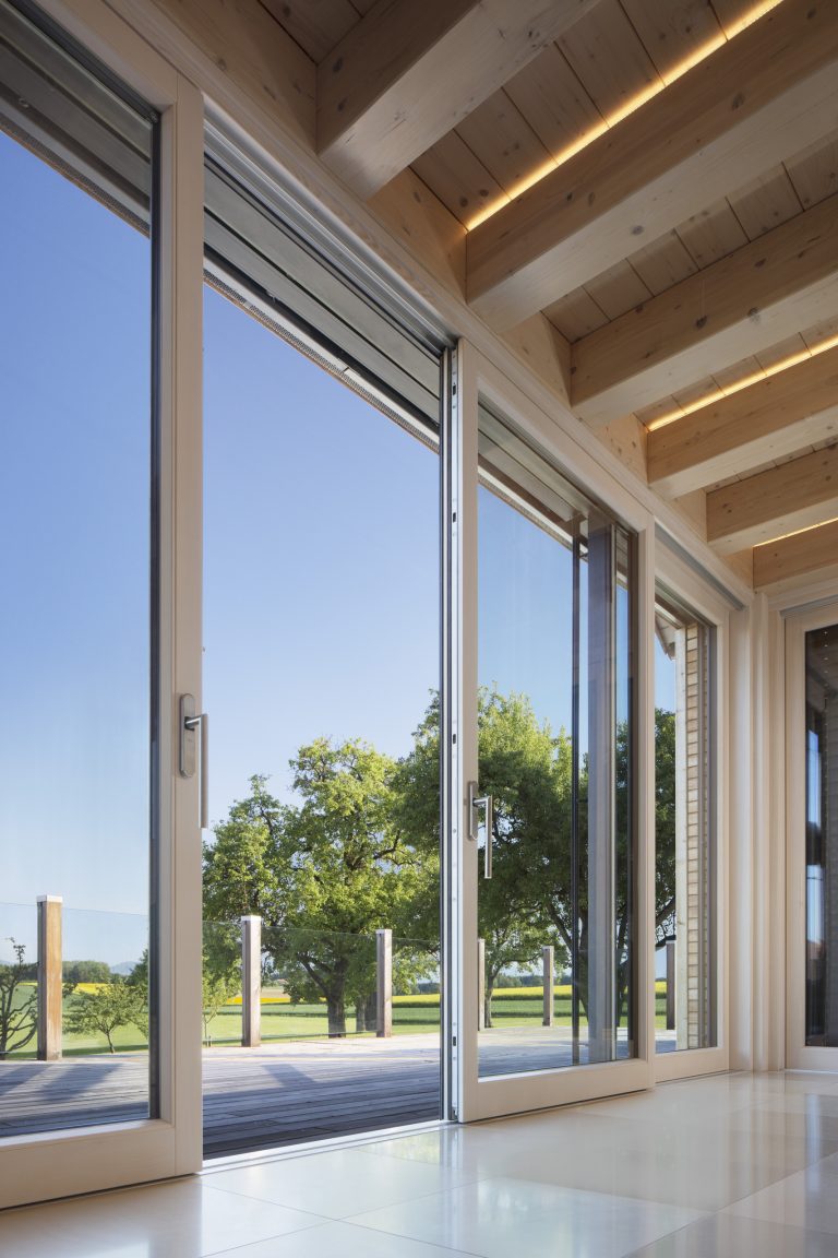 Barrierefreie und bodentiefe Glasschiebetür von Maderböck mit Blick auf die Holzterrasse.