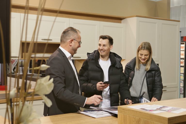 Ein Paar und ein Aussteller bei einem Beratungsgespräch in einer Schauküche auf der Messe Oberwart.