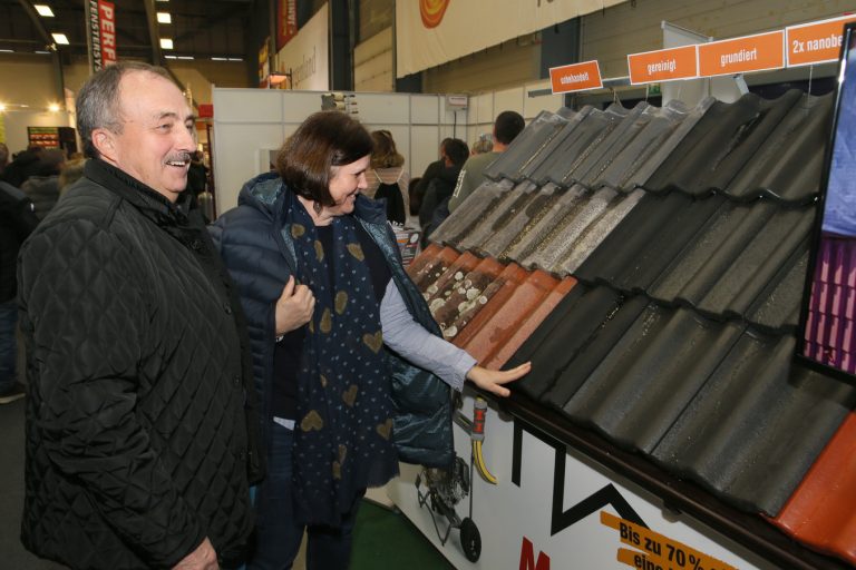 Besucher der Messe Oberwart bei der Begutachtung verschiedener Muster für Dachziegeln.