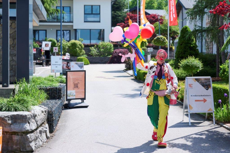 Ein Clown mit Ballontieren begrüßt die kleinsten Besucher im Musterhauspark Eugendorf.