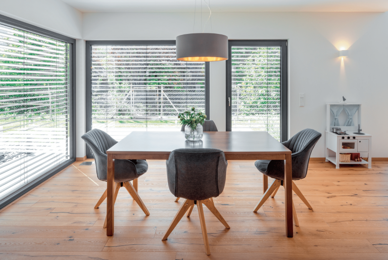 Helles, offenes Esszimmer in einem Regnauer Fertighaus mit großen Fensterfronten.