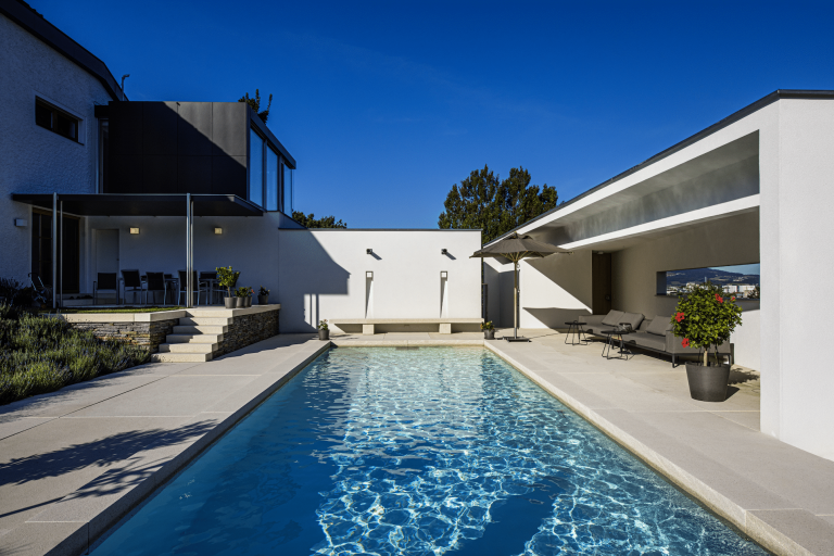 Schattige Terrasse mit vielen Sitzmöglichkeiten und großem Swimmingpool von SAUNA-SCHWIMMBAD RUHA Stelzmüller.