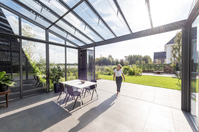 Wintergarten mit barrierefreiem Zugang zum Garten, deckenhohen Glasfalttüren und einem Glasdach von Solarlux.