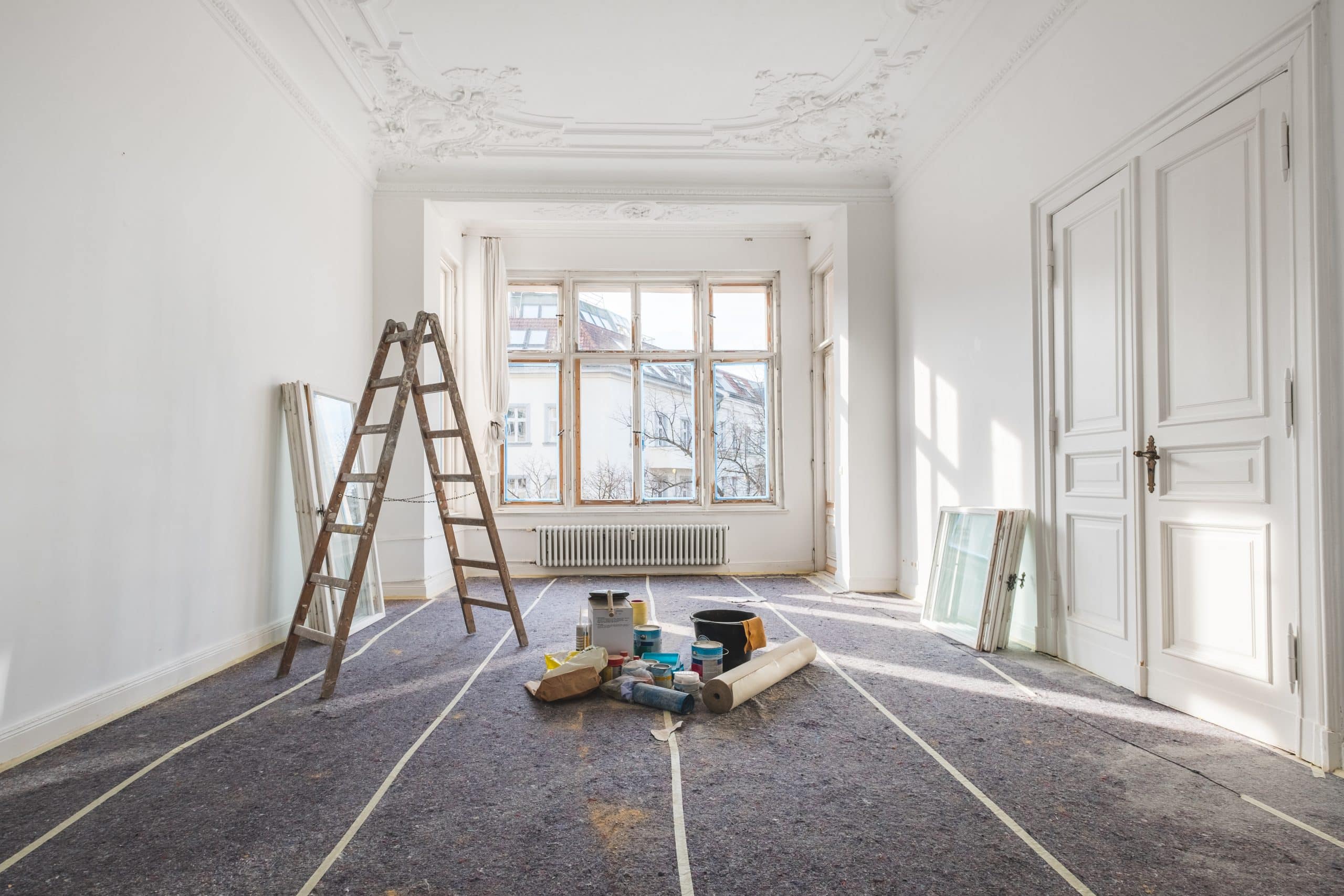 Sanierungsarbeiten in einem Altbau mit großen Fenstern.