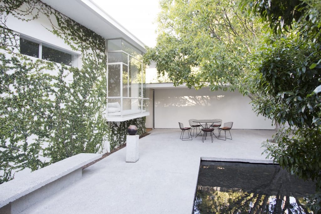 Einfamilienhaus mit Terrasse und angrenzendem Teich.